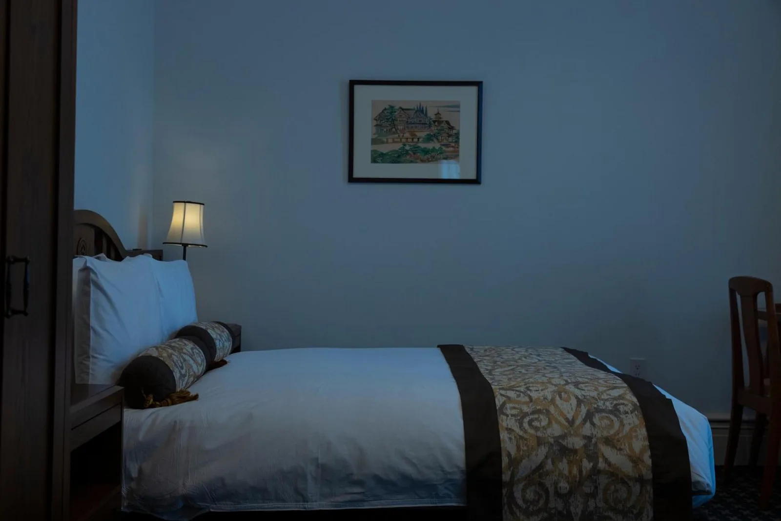 A cozy bed setup in a room at The Fujiya Hotel in Hakone, showcasing its decorative style.