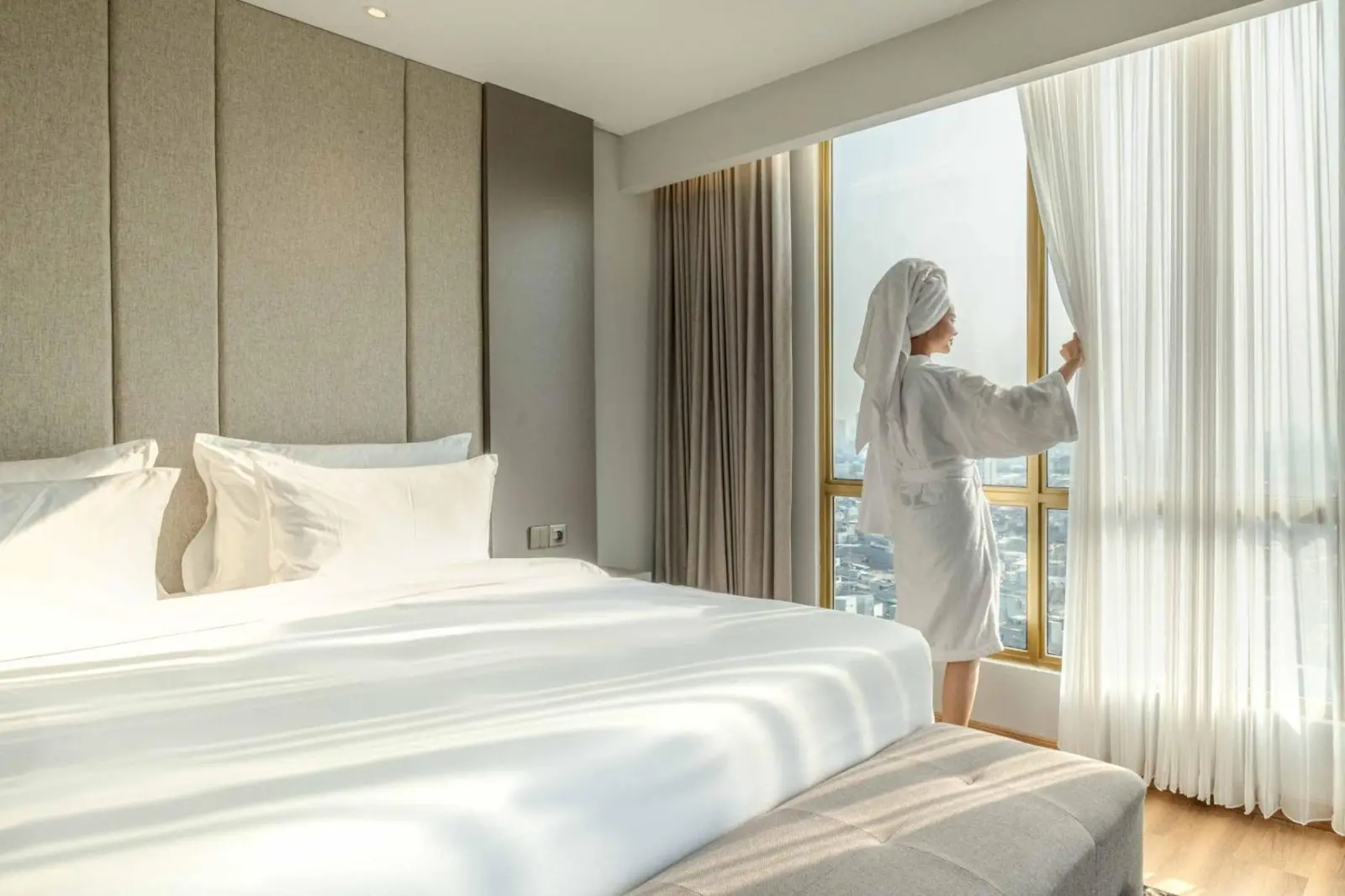 Personne profitant de la vue depuis une chambre au The Grand Platinum Jakarta
