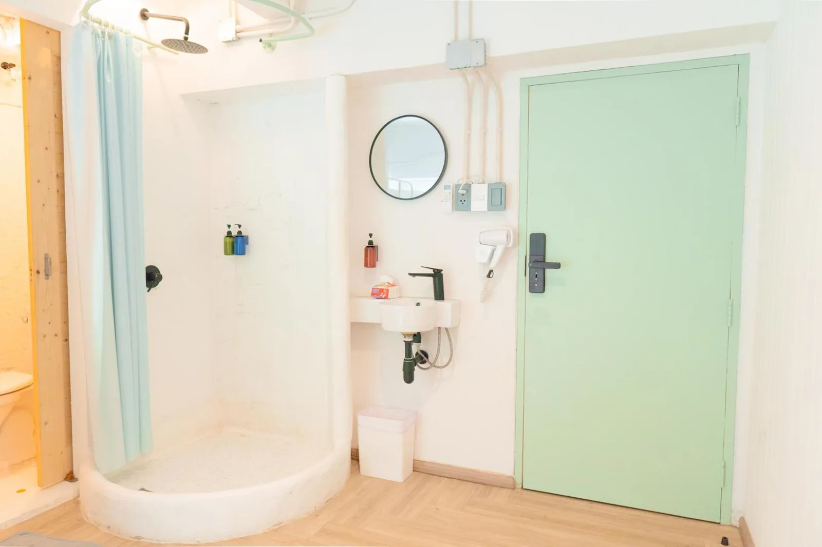 Bathroom area at The Green Khaosan Bangkok with shower, sink, and mint green door