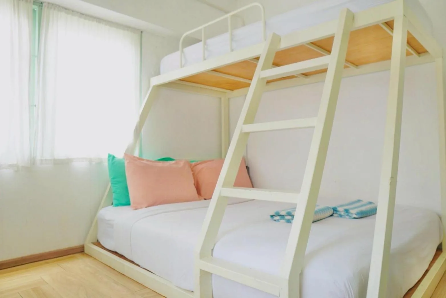 Cozy bunk bed setup at The Green Khaosan Bangkok with white frame and pastel pillows
