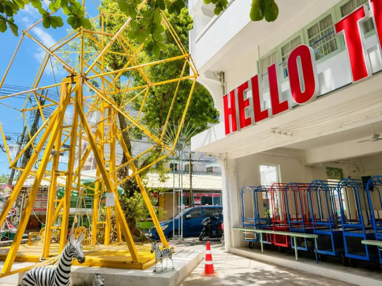 Exterior view of The Green Khaosan Bangkok in Bangkok with a bright yellow geometric sculpture and hotel signage