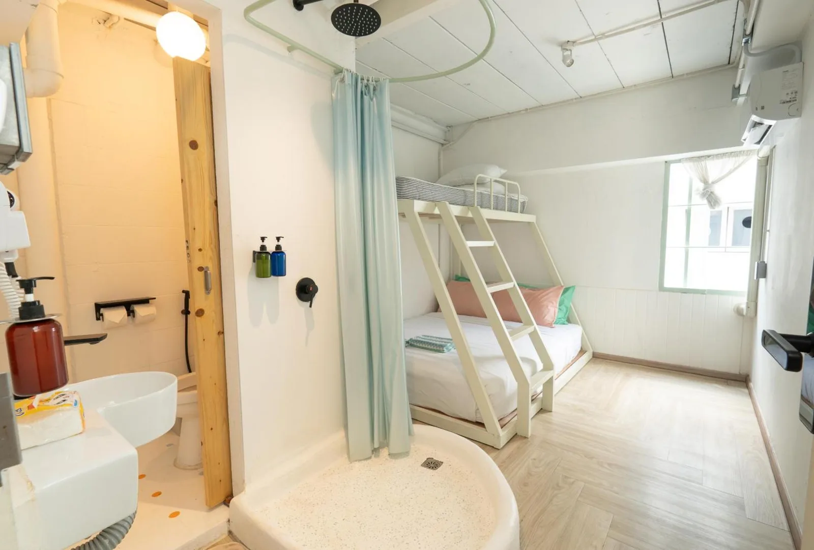 Wide room interior at The Green Khaosan Bangkok with bunk bed, bathroom, and shower area