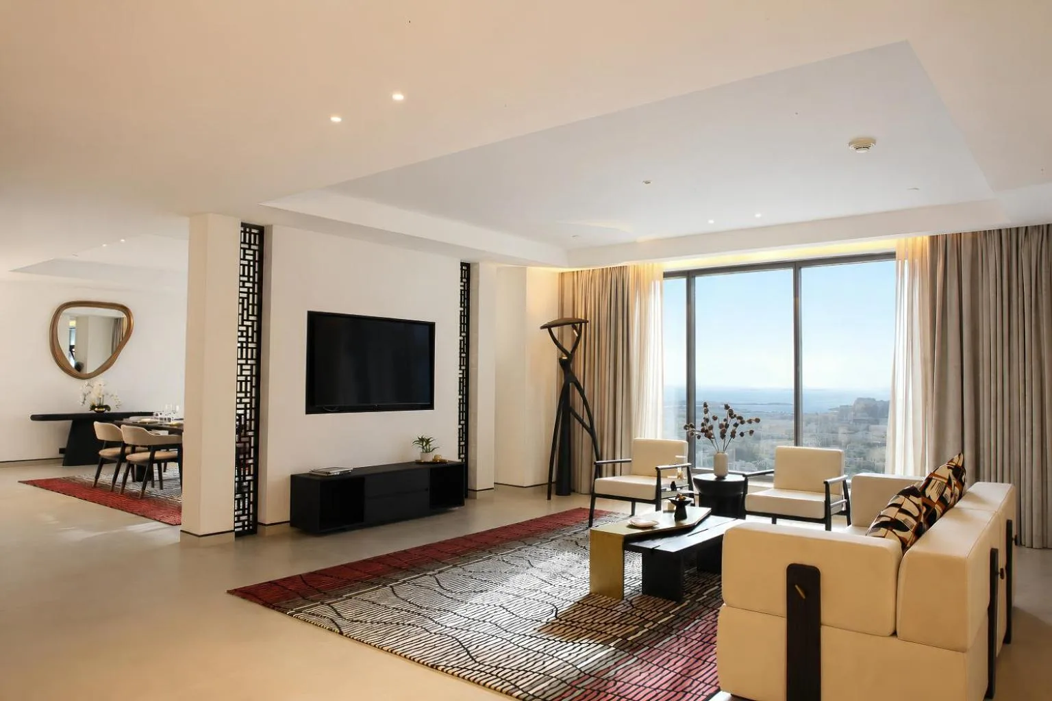 Zona de estar de una suite de lujo con vistas a la ciudad en The H Dubai