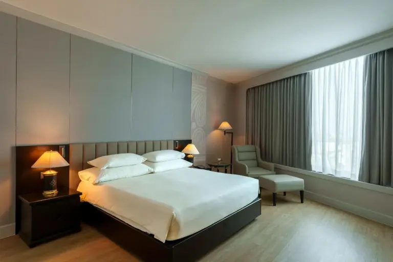 The Heritage Grand Khon Kaen Hotel and Convention – Hotel in Khon Kaen, Thailand – ein Hotelzimmer mit Bett und Stuhl im The Heritage Grand Khon Kaen Hotel and Convention in Khon Kaen