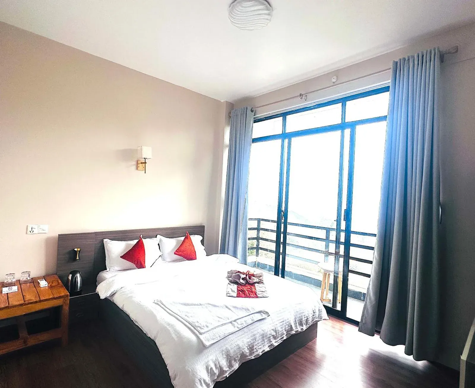 The Himalayan Ridge – Hotel in Nagarkot, Nepal – ein Schlafzimmer mit einem Bett mit roten und weißen Kissen im The Himalayan Ridge in Kathmandu