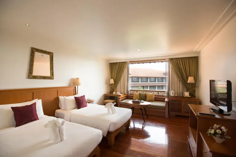 Habitación doble con dos camas en The Imperial River House Resort, Chiang Rai con suelos de madera pulida y zona de ventana