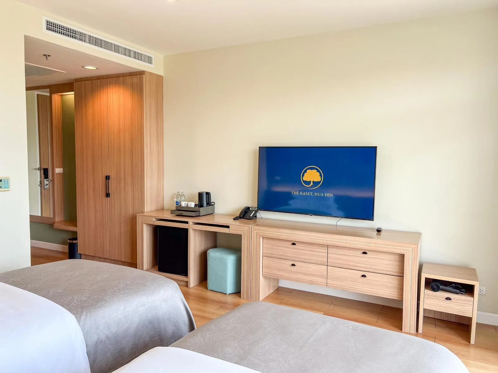 Twin guest room at The Kaset, Hua Hin with TV, desk, and wardrobe in Hua Hin, Thailand