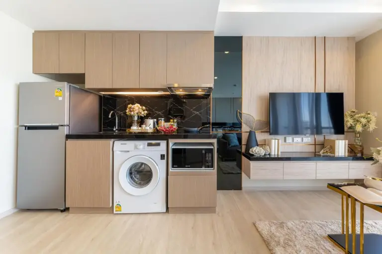 Compact kitchenette at The Panora Pattaya by PH with refrigerator, washing machine, and microwave in Pattaya