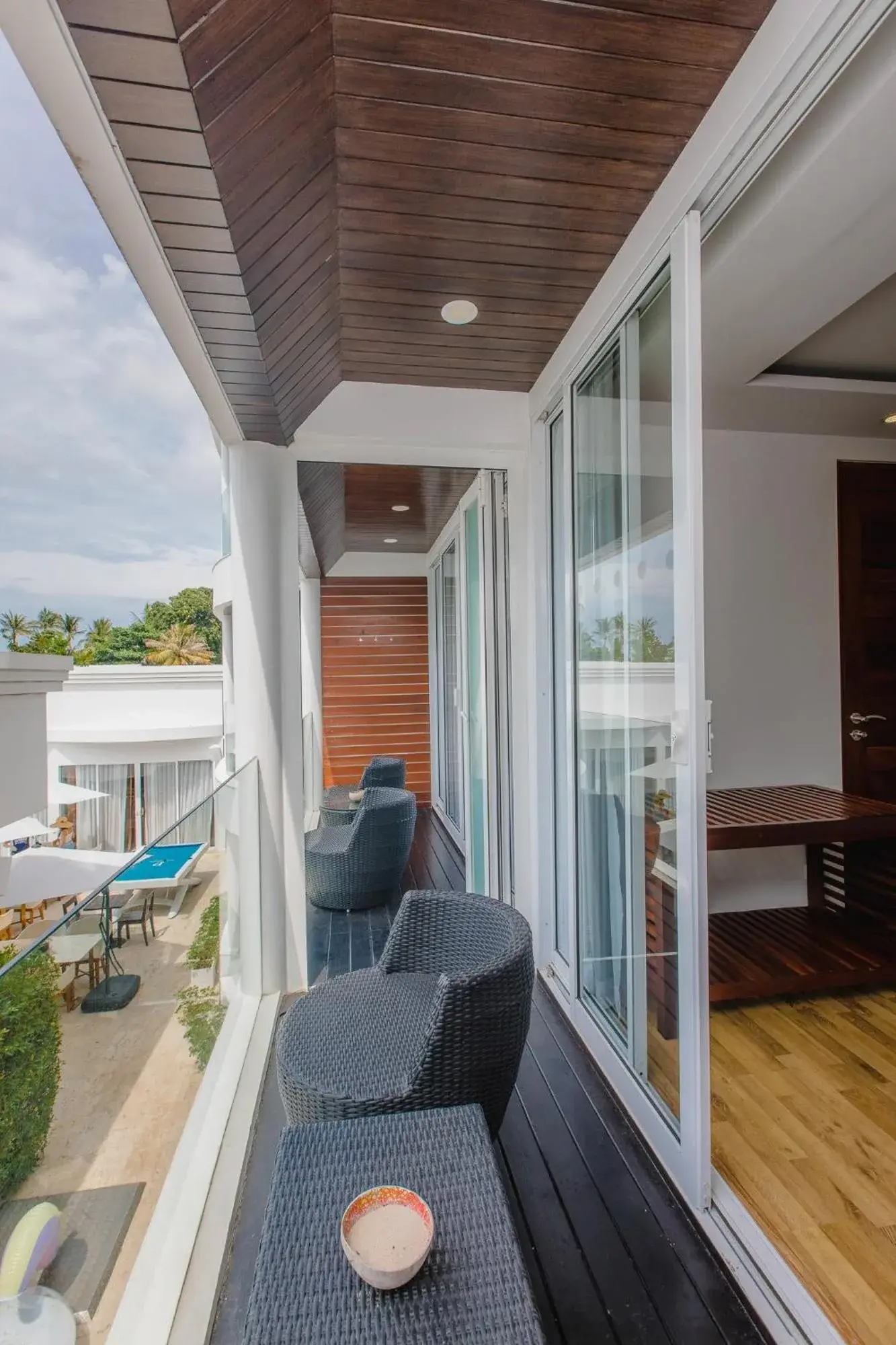 Pasillo de balcón en la planta superior de The Privilege Hotel Ezra Beach Club en Koh Samui con asientos al aire libre