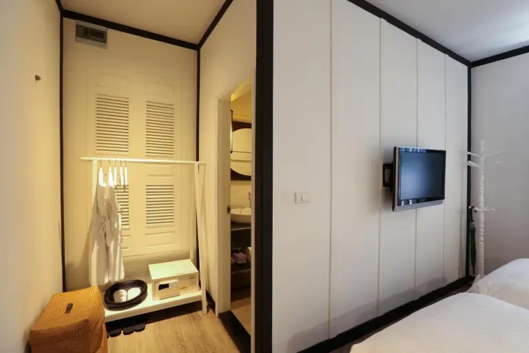 Closet and bedside area in a guest room at The Raweekanlaya Bangkok Wellness Cuisine Resort Bangkok