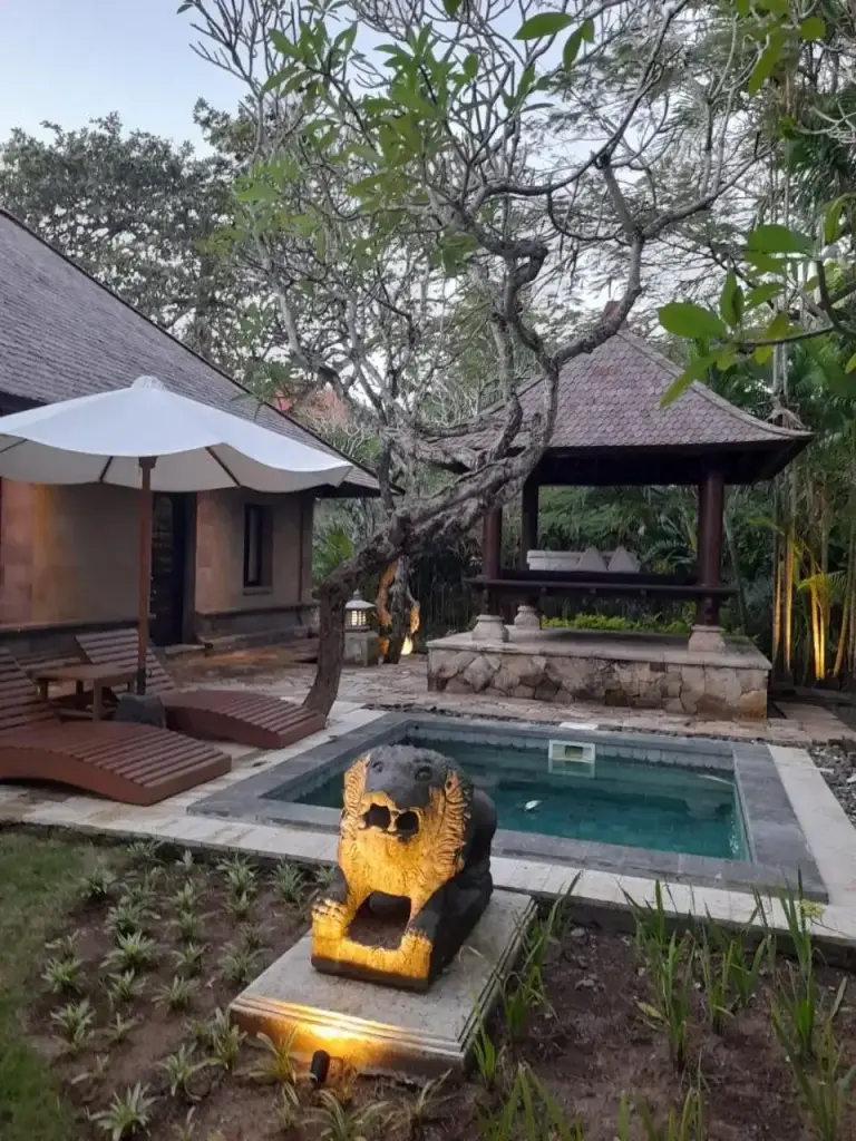 Una zona de estar exterior con una estatua en The Royal Beach Seminyak Bali