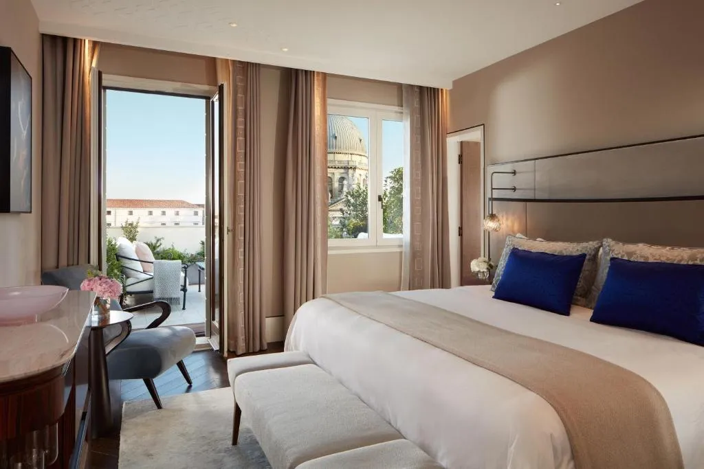 The St. Regis Venedig – Hotelzimmer mit einem großen Bett mit blauen Kissen im The St. Regis Venedig in Venedig