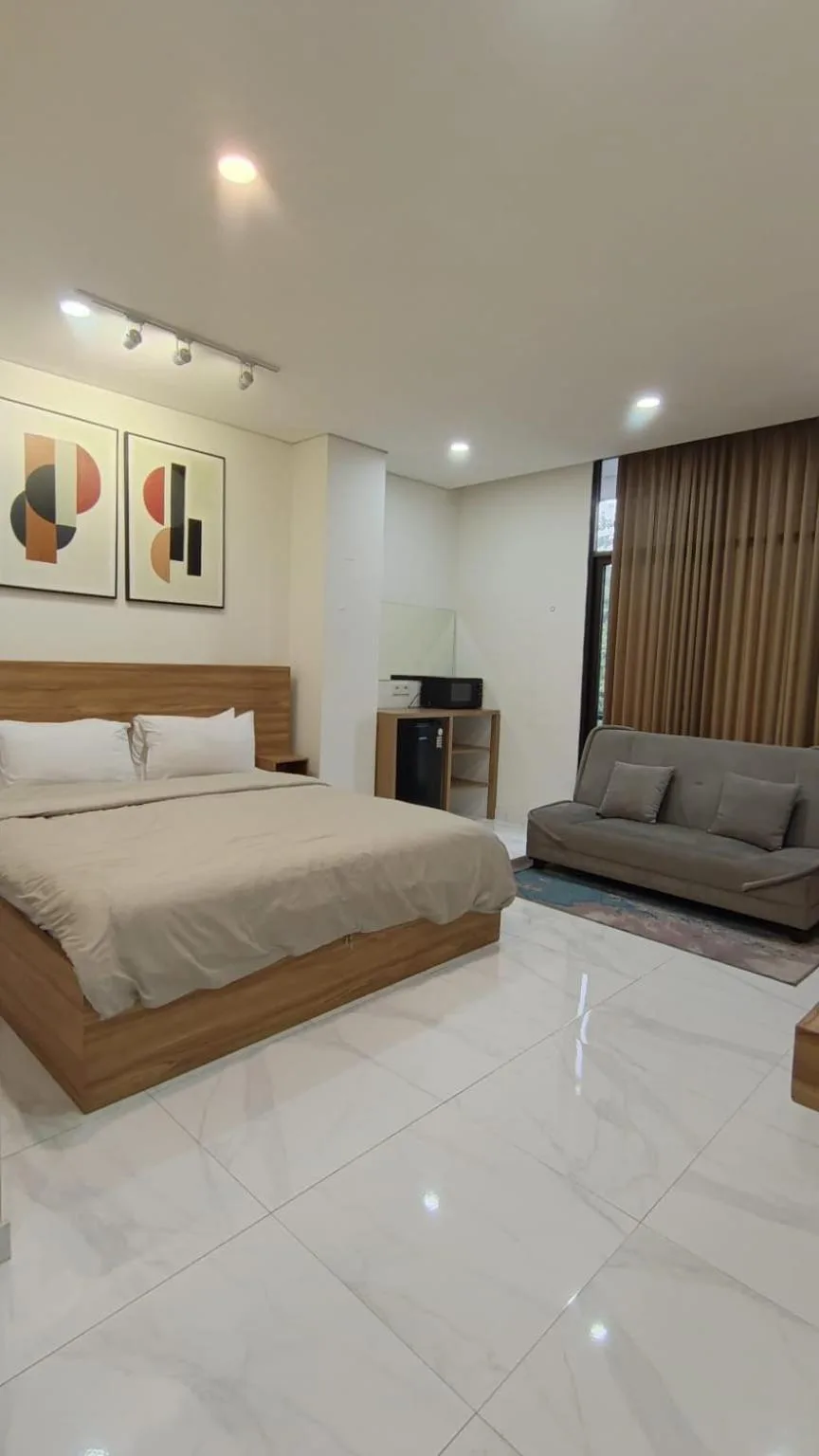 Amplia suite dormitorio en The W Residence Jakarta con una cama grande y zona de estar.