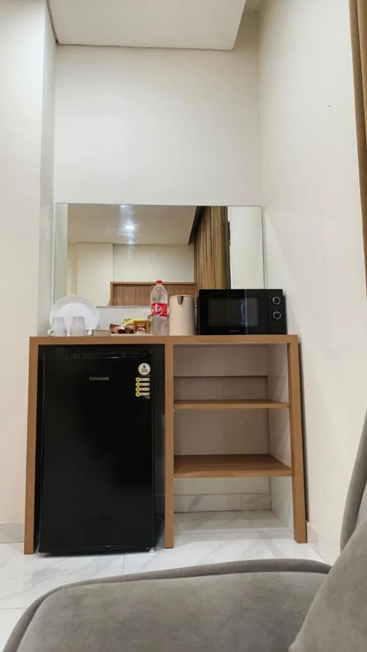 Minipantry en The W Residence Jakarta con nevera, microondas, hervidor y espejo de tocador.