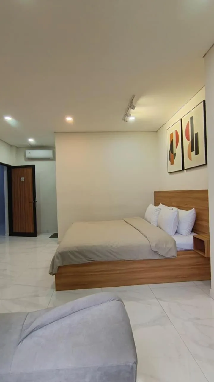 Dormitorio de estilo estudio en The W Residence Jakarta con una cama, un sofá y distribución de planta abierta.