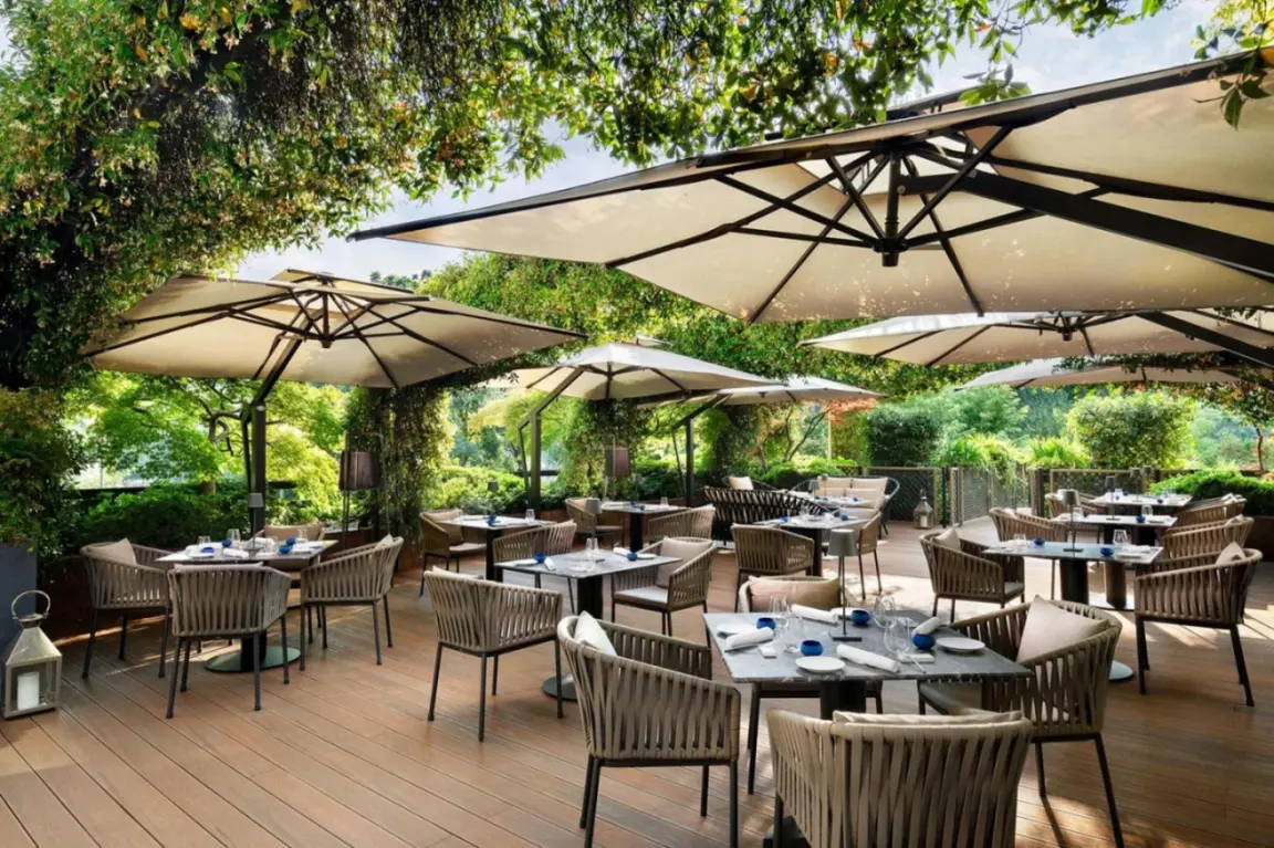 The Westin Palace, Milan área de comedor al aire libre con mesas y sombrillas