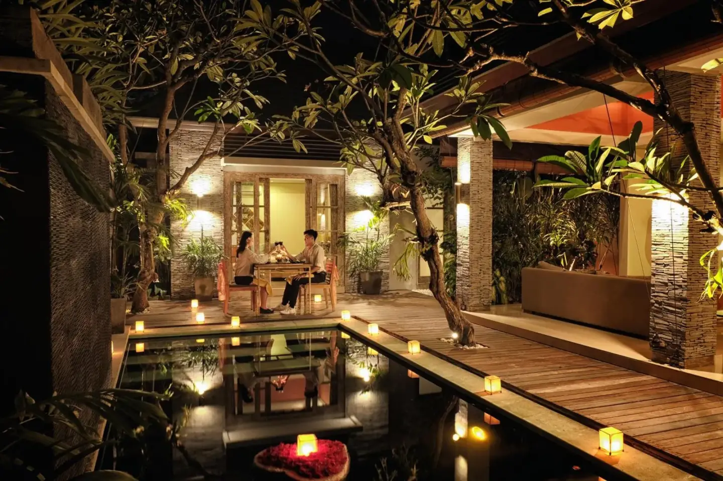 Couple dining poolside at The Wolas Villas in Seminyak