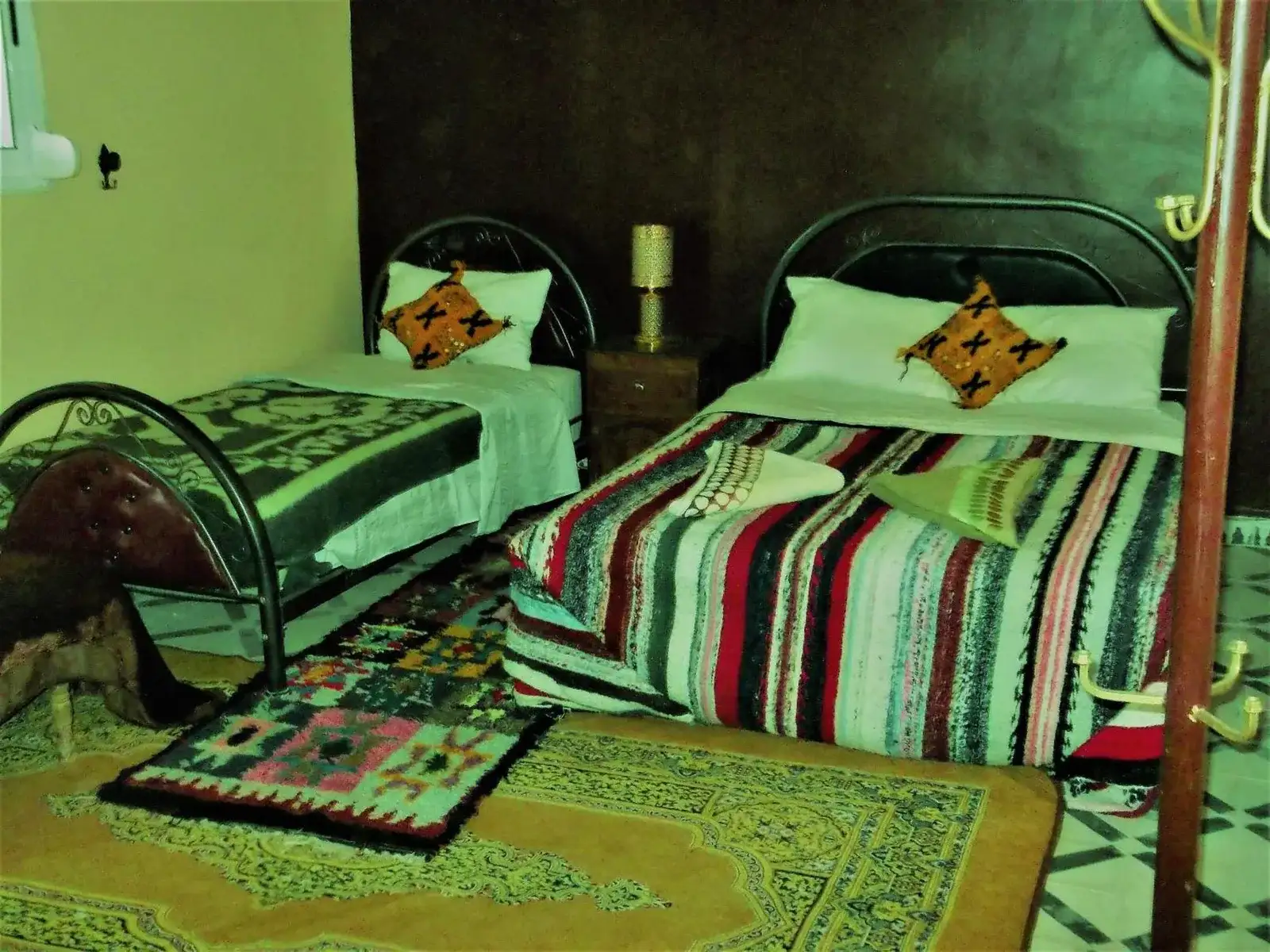 Zona compacta de lavabo en Tifinagh Guest House en Merzouga con espejo y paredes amarillas