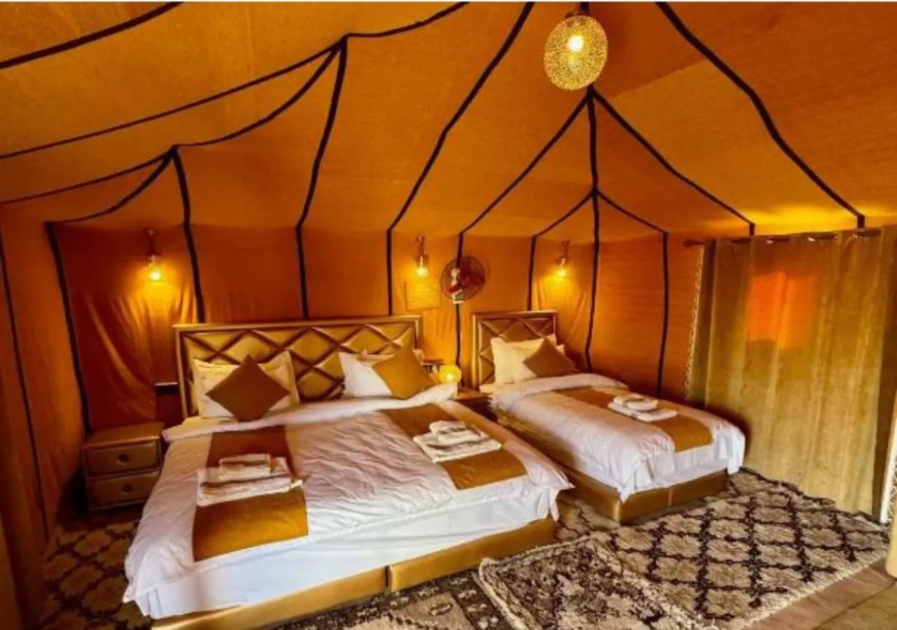 Tinariwen Luxury Camp – Merzouga, Morocco hotel – a bedroom with two beds with towels on it at Tinariwen Luxury Camp in Merzouga