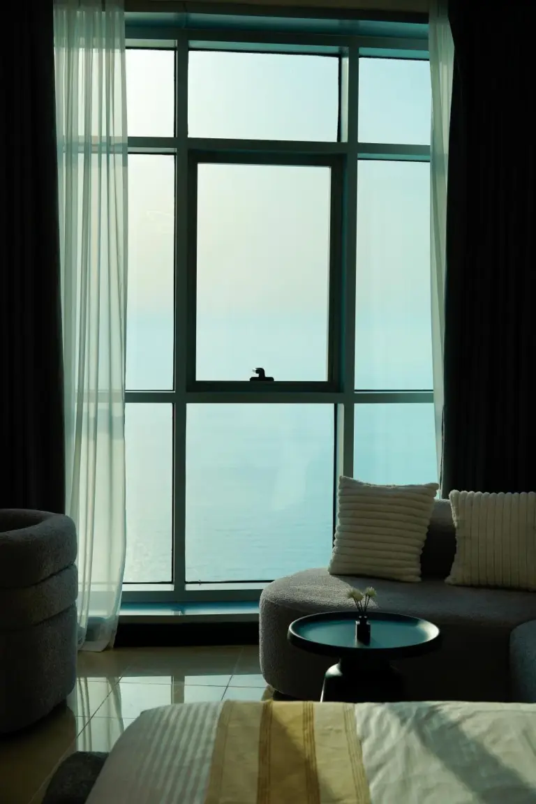 Ventana de habitación de hotel con vistas al mar en Ajman