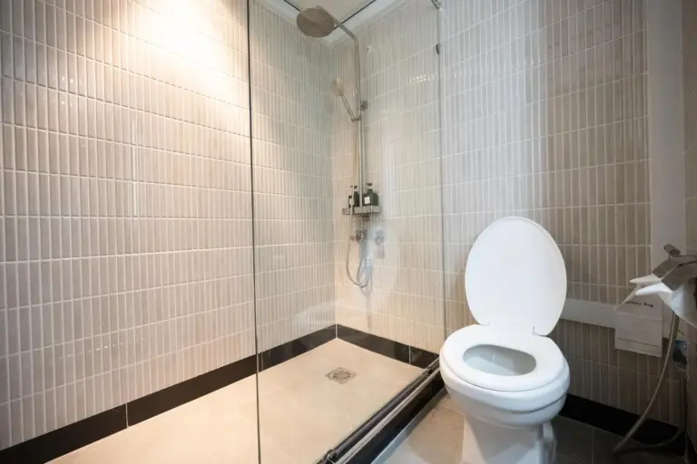 Salle de douche du Town in Town Hotel Bangkok avec paroi vitrée et toilettes