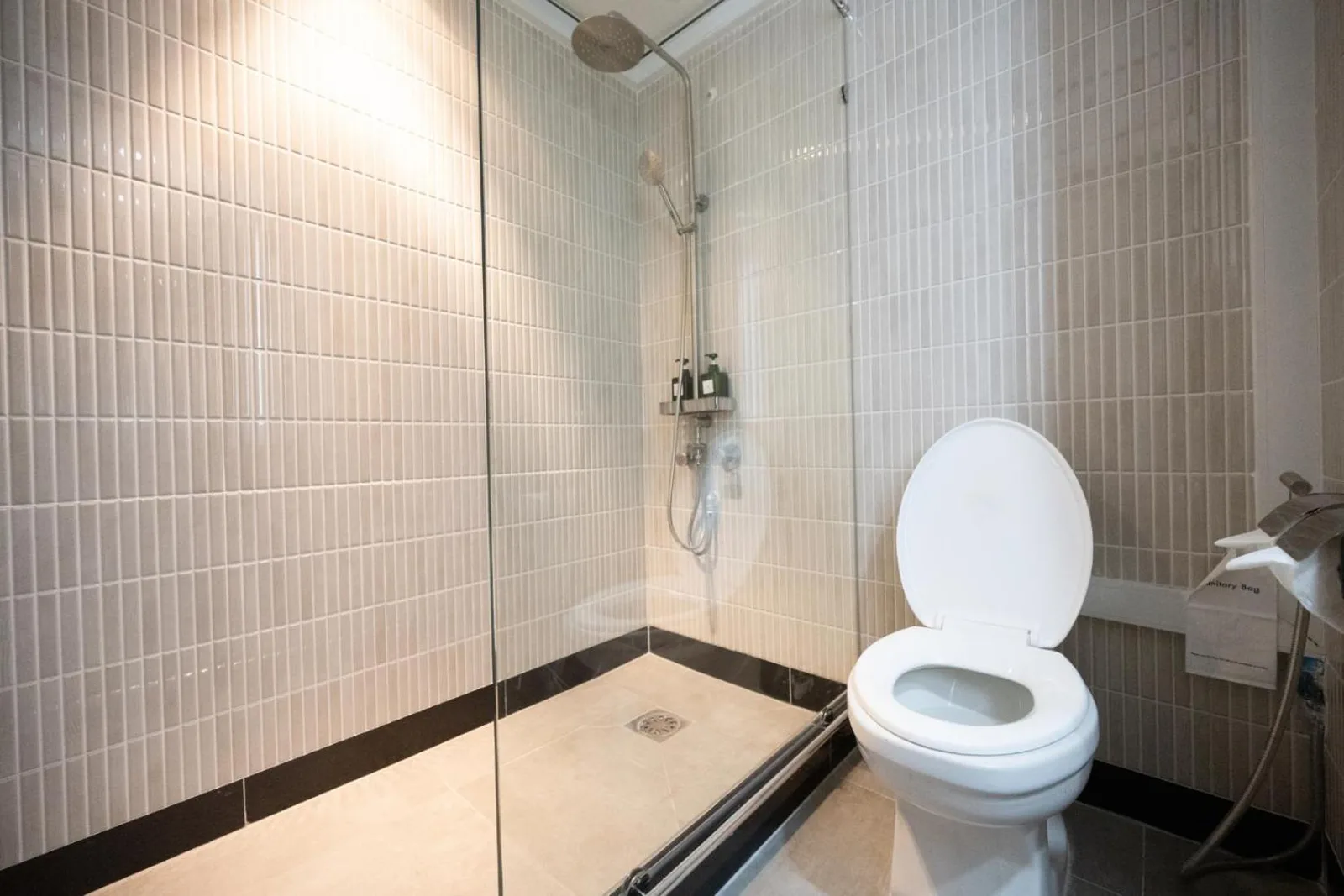 Salle de douche du Town in Town Hotel Bangkok avec paroi vitrée et toilettes