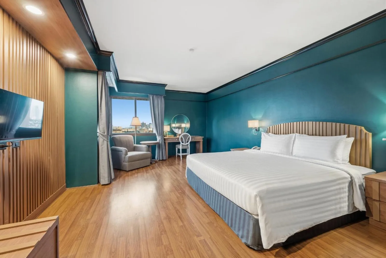 Chambre de suite du Town in Town Hotel Bangkok avec lit king-size, fauteuil de salon et espace de travail