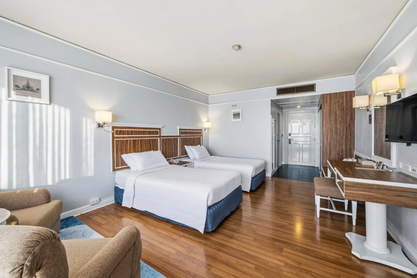 Chambre twin du Town in Town Hotel Bangkok avec deux lits simples, bureau et fauteuil