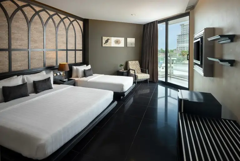 Habitación twin de TSix5 Quarter Pattaya con dos camas, suelo de baldosas oscuras y vistas desde el balcón