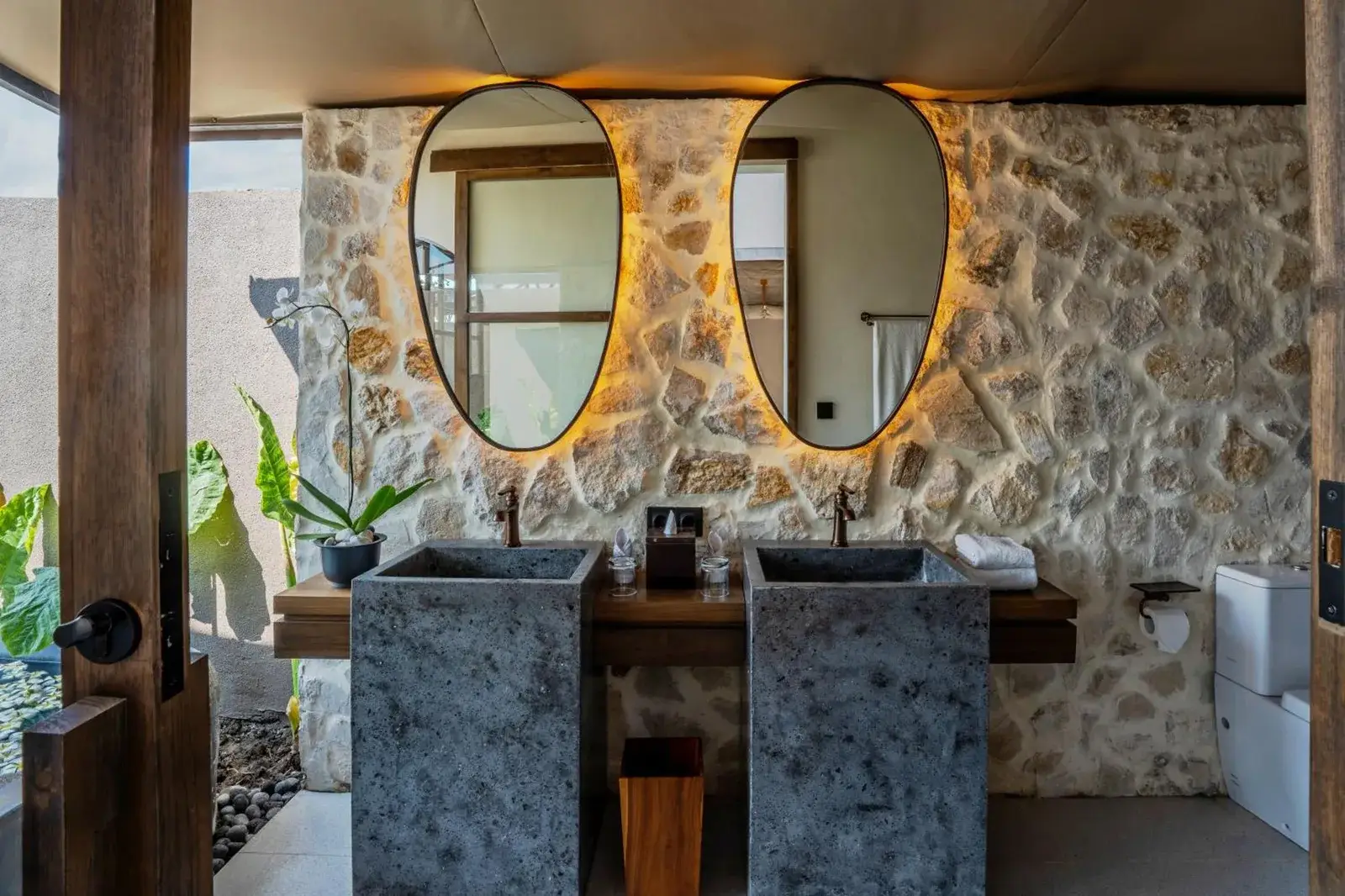 Salle de bains élégante à Ubud Mas Glamping Luxury Tent avec équipements en pierre.