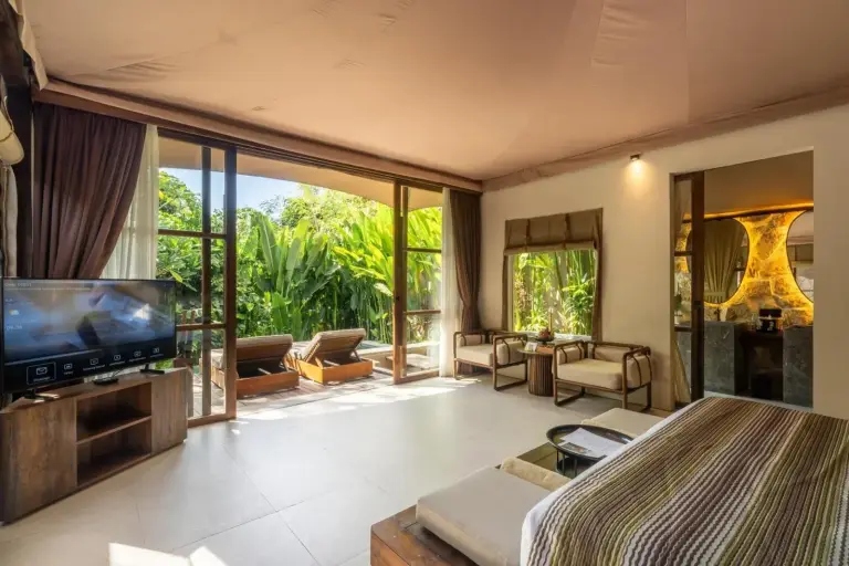 Coin salon confortable à Ubud Mas Glamping Luxury Tent avec vue sur l’extérieur.