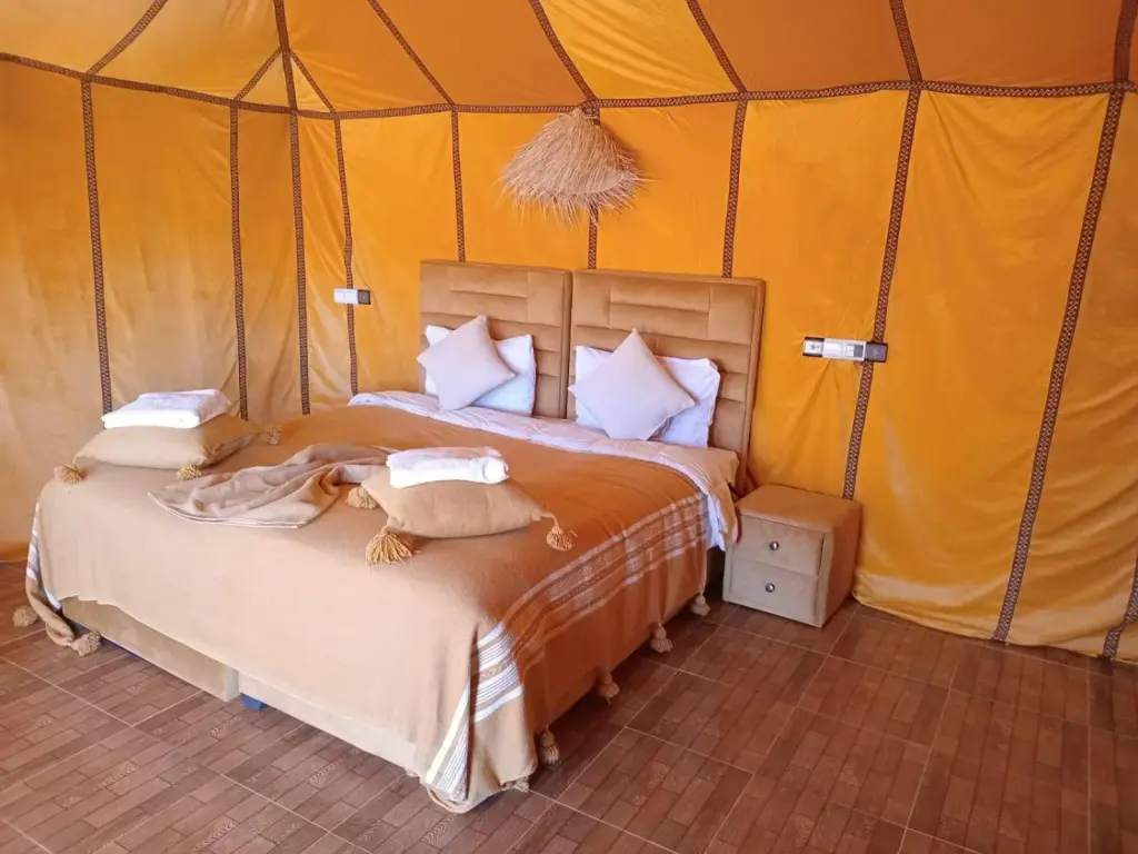 Cozy tent bedroom at Unique Sahara Camp in Merzouga with a large bed and desert-style decor