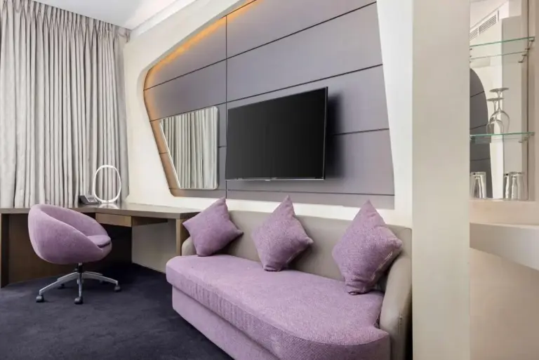 Interior de habitación del V Hotel Dubai con TV y asientos