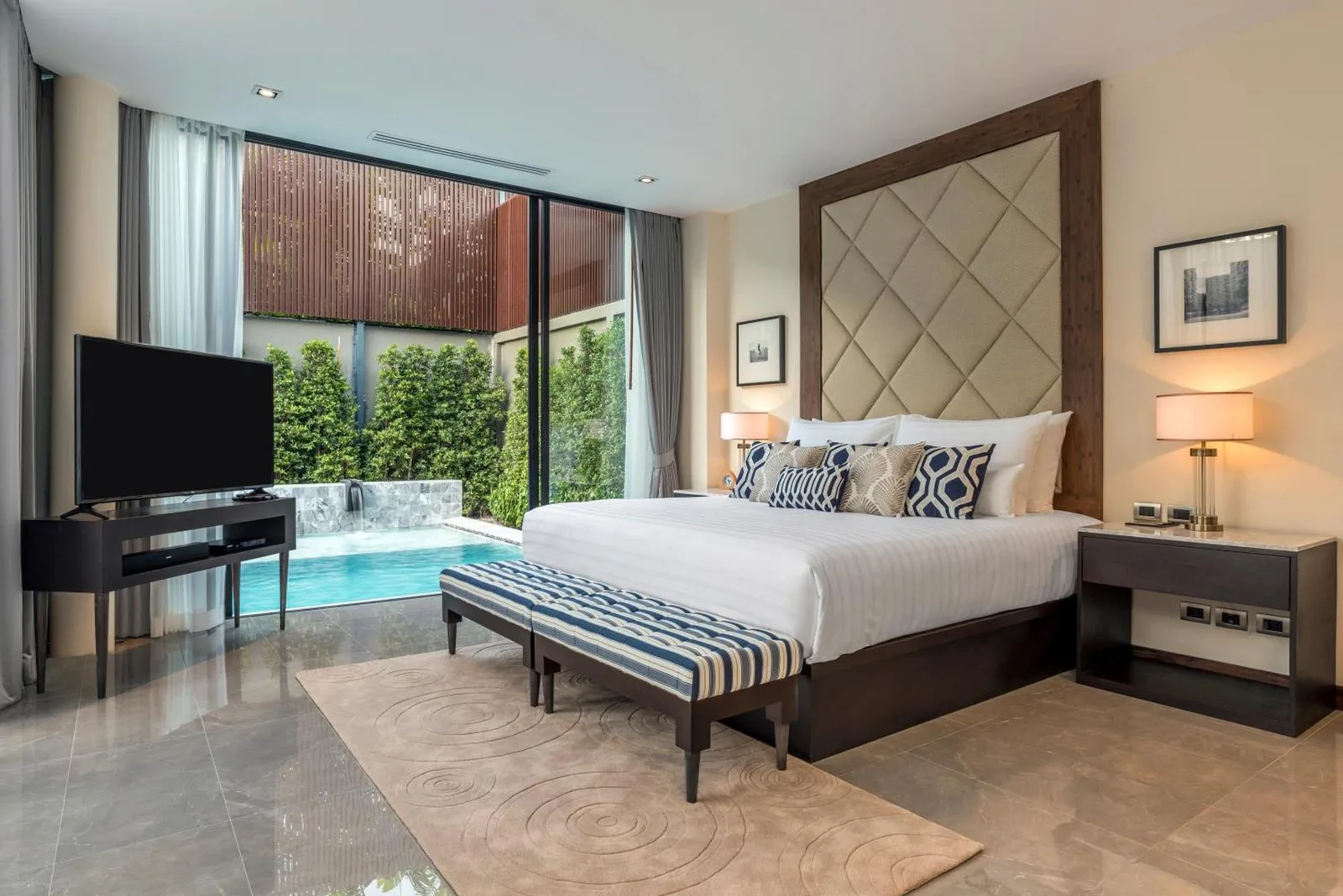 a table of food in a wicker basket next to a pool at V Villas Hua Hin - MGallery Collection in Hua Hin