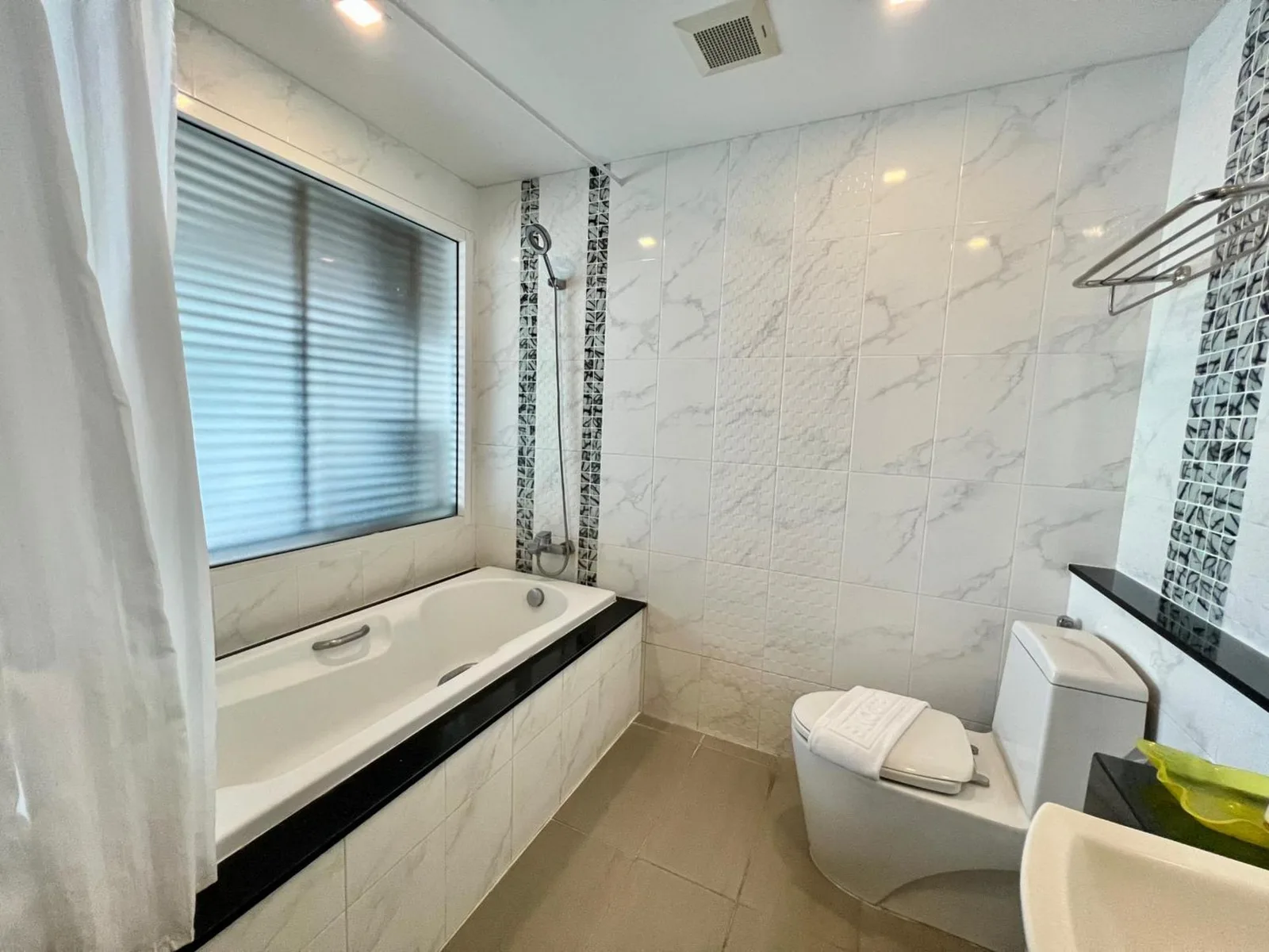 Vareena palace hotel – Hotel in Pattaya, Thailand – ein Badezimmer mit Badewanne, Toilette und Fenster im Vareena palace hotel in Pattaya North