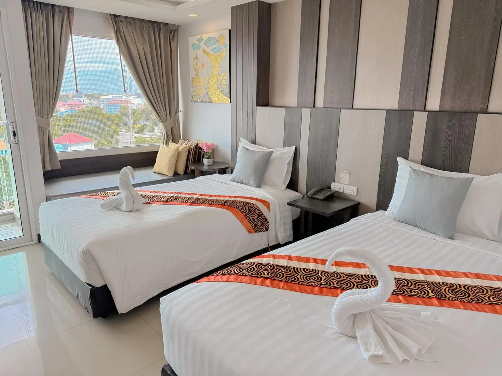 Zweibettzimmer im Vareena Palace Hotel in Pattaya mit zwei Einzelbetten, Blick aus dem Fenster und dekorativen Kissen.