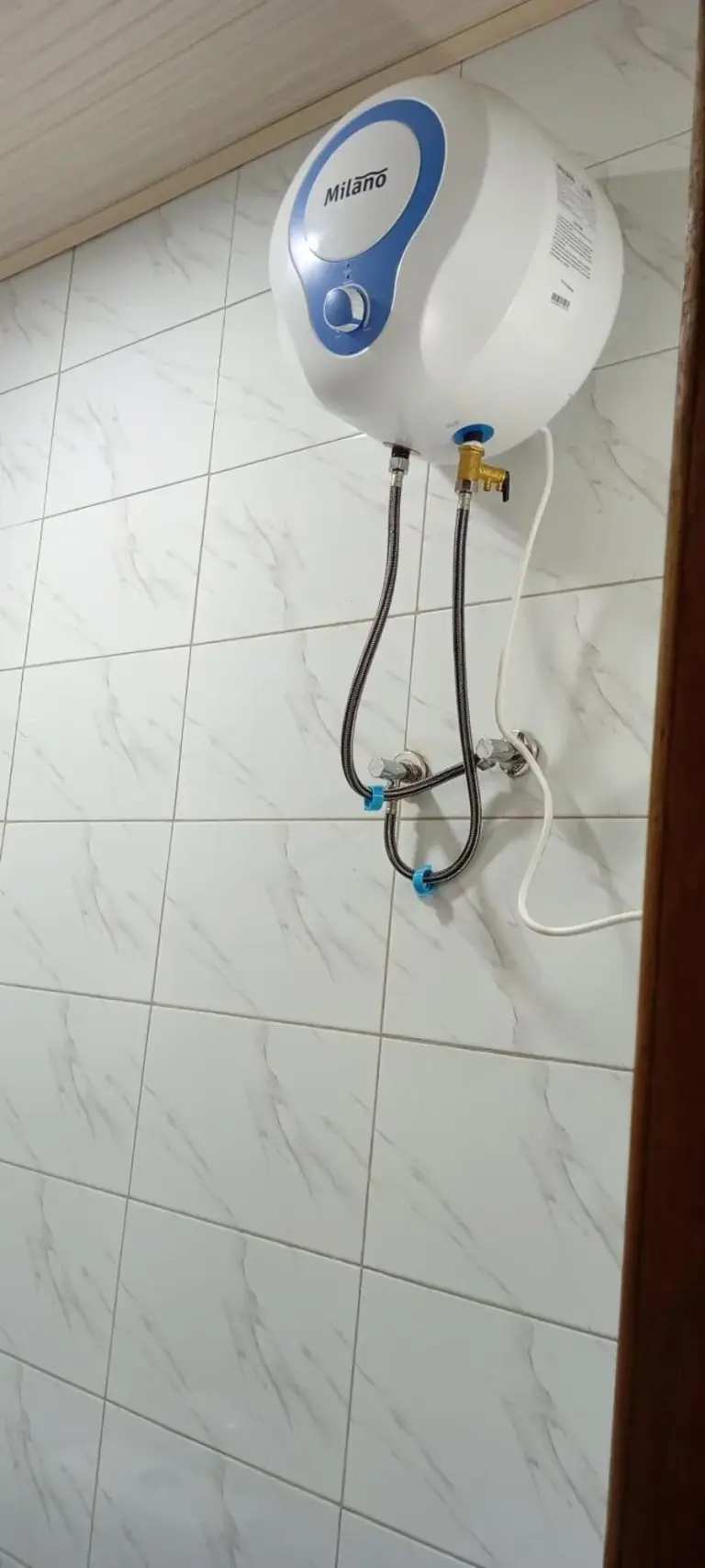 Warmwasserbereiter im Badezimmer des VENUS APARTMENT Kigali in Nyamata an einer gefliesten Wand montiert.