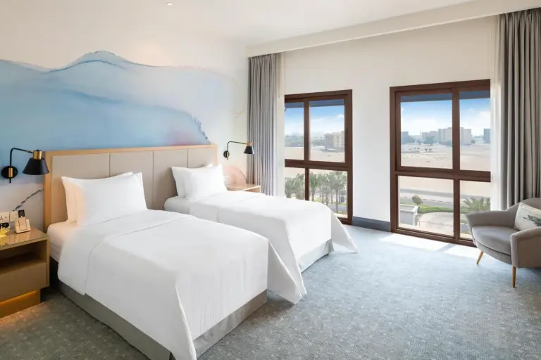 Twin guest room at Vida Beach Resort Umm Al Quwain with sea view windows and coastal decor