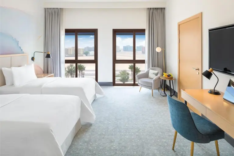 Spacious twin room at Vida Beach Resort Umm Al Quwain with balcony windows and resort view