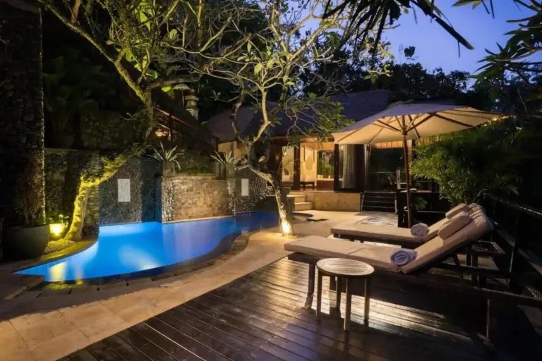 Zona de la piscina iluminada en Villa Cella Bella Ubud por la noche