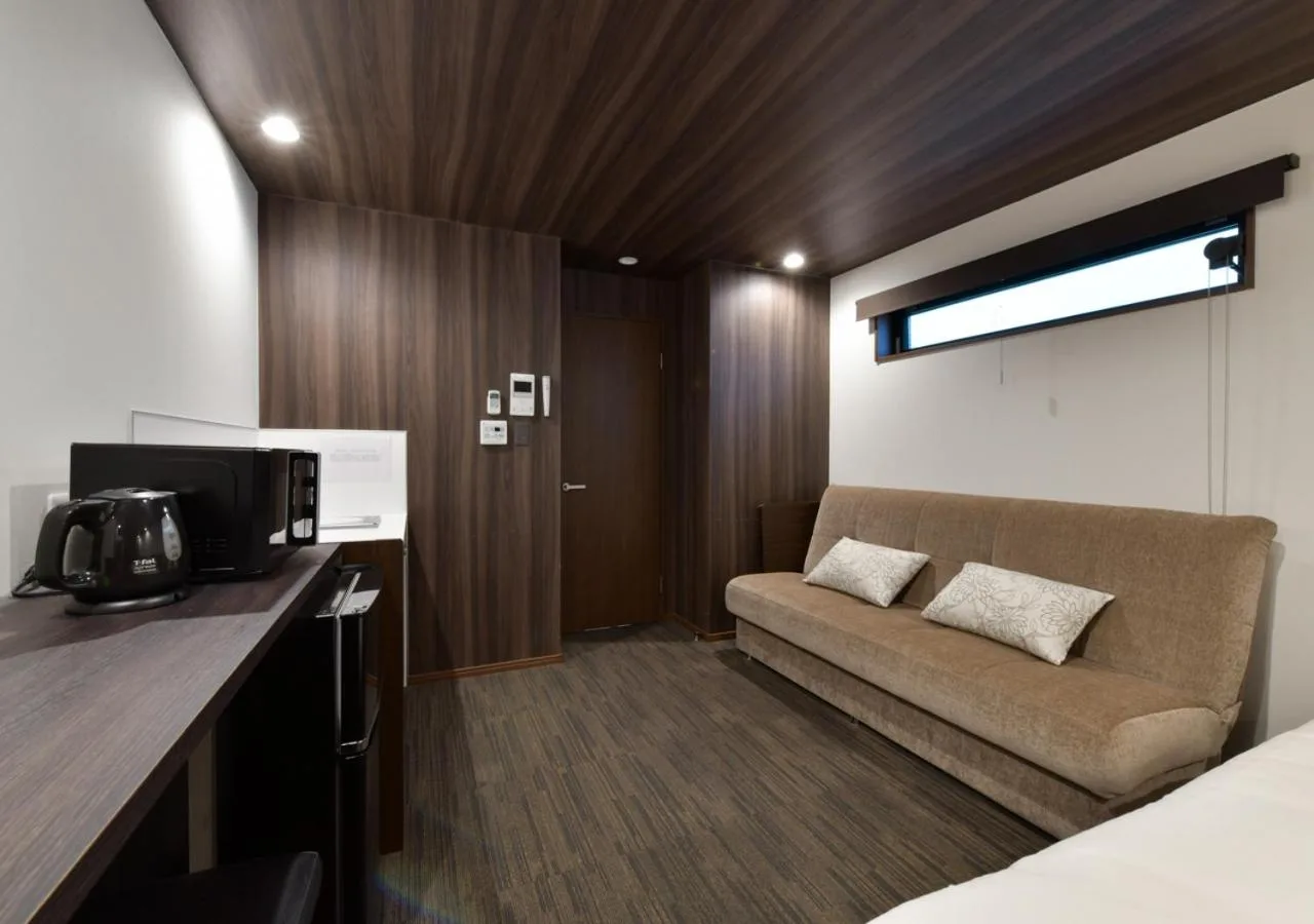 Villa Front Kyoto Seimei en Kioto mostrando una habitación de huéspedes con sofá, camas twin y techo de madera