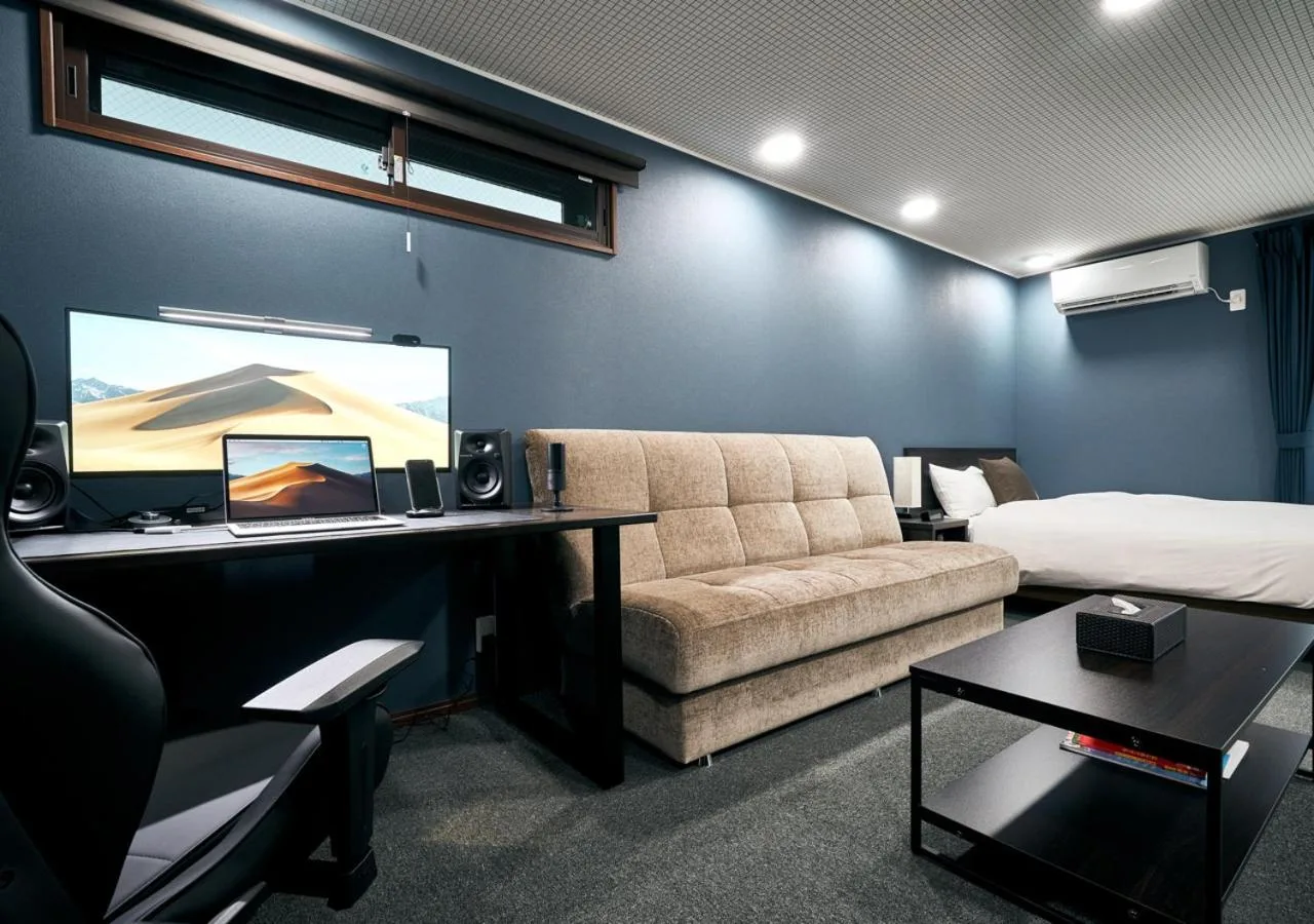 Villa Front Kyoto Seimei en Kioto mostrando una habitación estudio moderna con sofá, cama, escritorio y TV