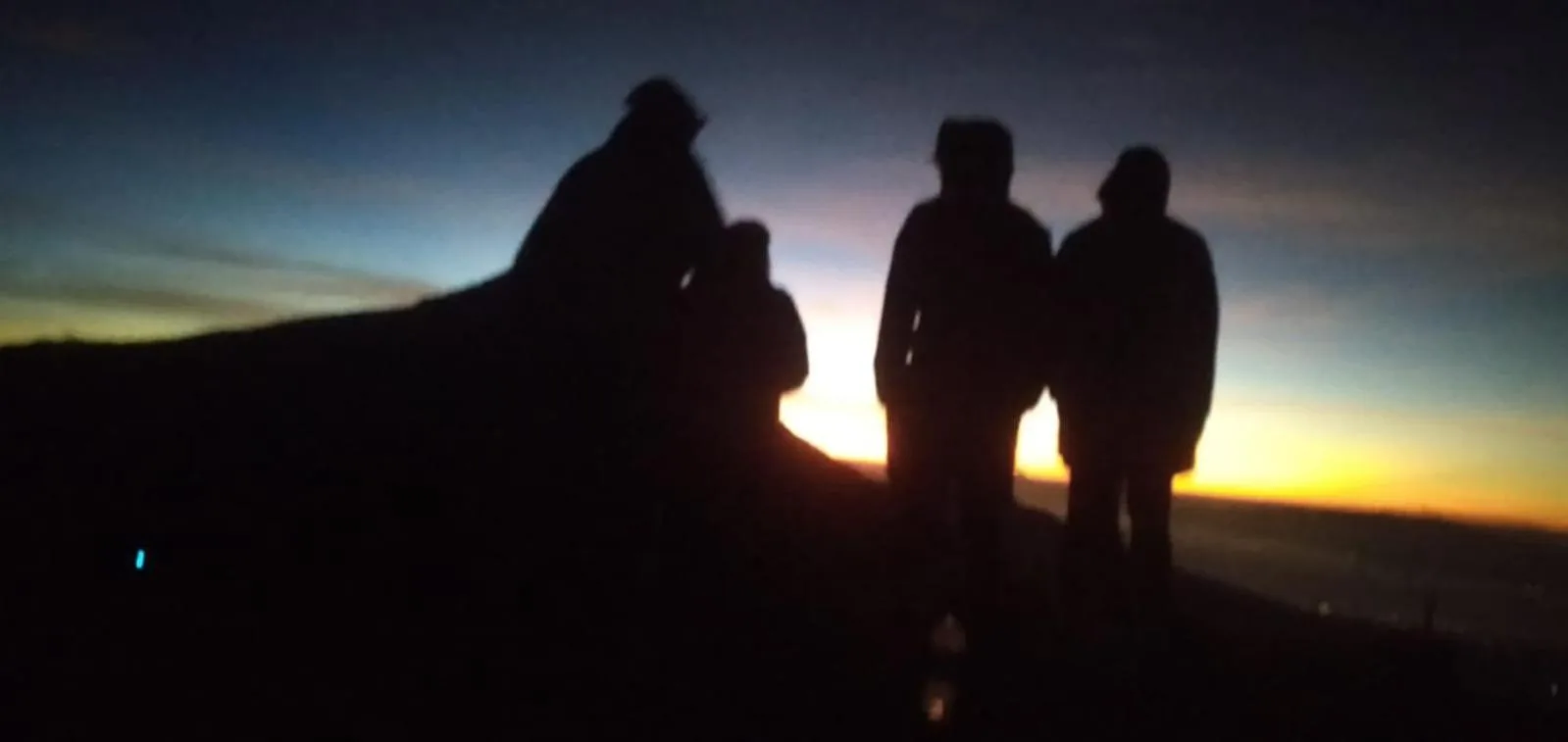 Als Silhouetten erkennbare Menschen bei Sonnenuntergang während eines Ausflugs im Freien nahe Villa Puri Karang Bayan in Mataram.