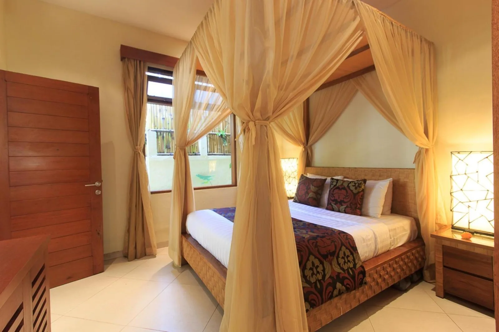 Gemütliches Schlafzimmer in Villa Seriska Seminyak mit Himmelbett