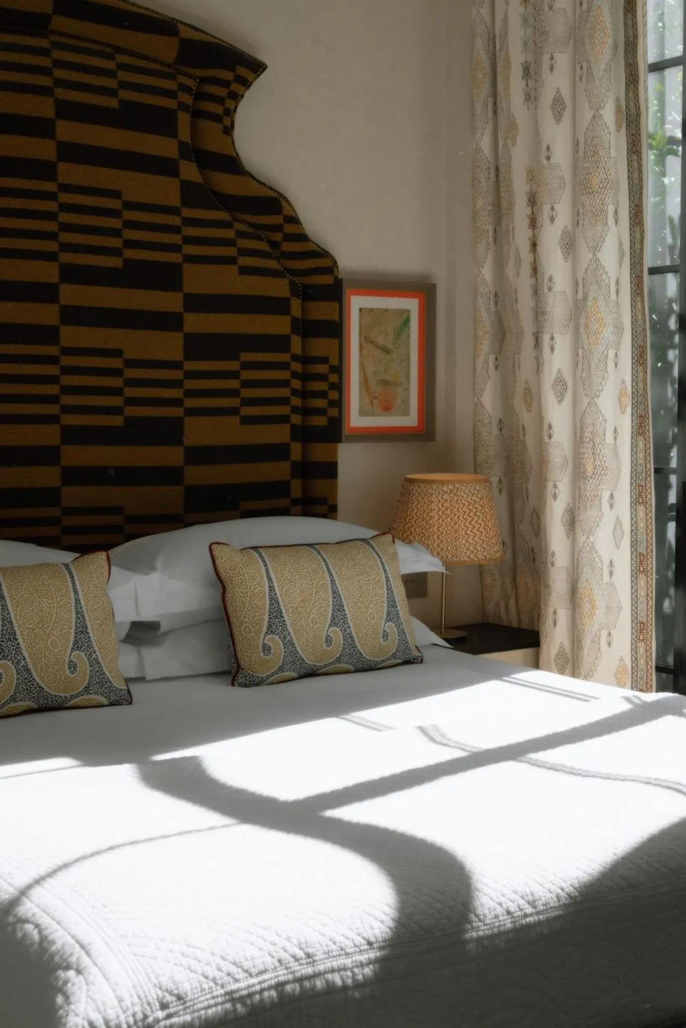 Dormitorio iluminado por el sol de Vmaison Brera Milano con almohadas decorativas