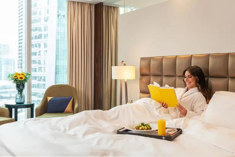 Gast entspannt in einem Bett im voco Bonnington Dubai by IHG in Dubai