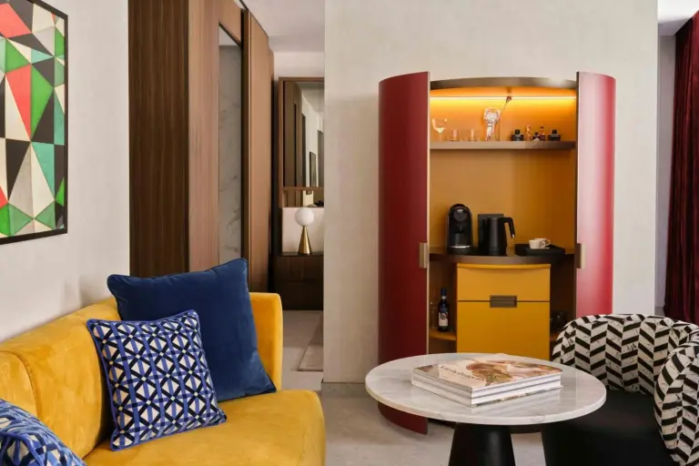 Espace de vie dans une suite à W Florence avec des meubles vibrants et un mini-bar