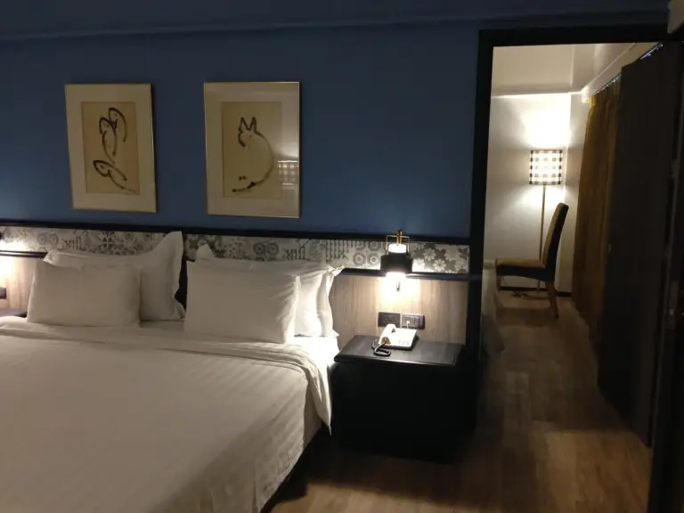 Blaues Kingsize-Zimmer im Hotel Witz Bangkok Ramkhamhaeng in Bangkok mit großem Bett und Blick auf den Flur