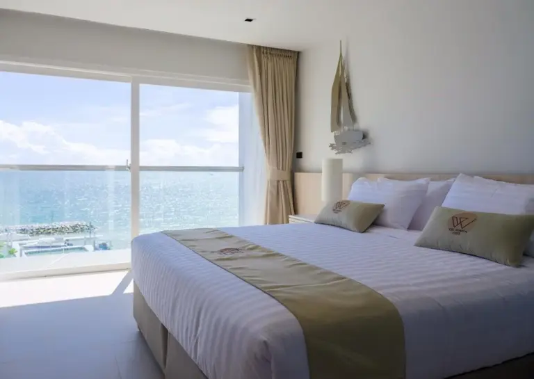 Sea view suite bedroom at Worita Cove Hotel in Pattaya with balcony, lounge chair, and ocean view.