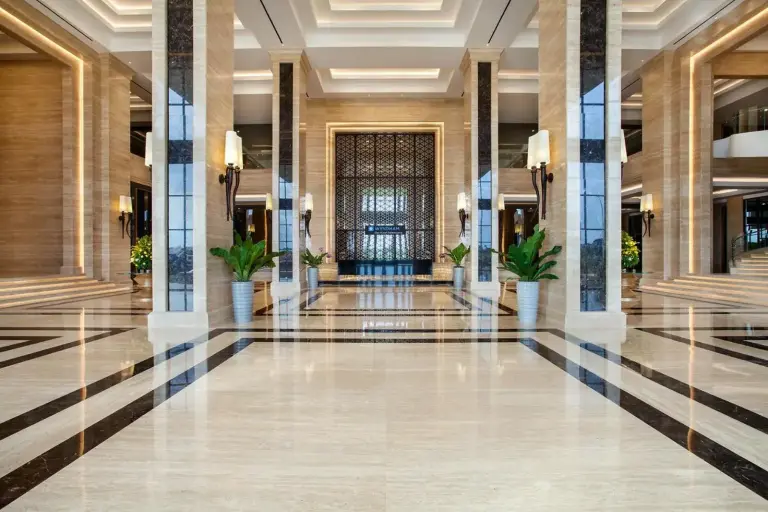 Gran vestíbulo de Wyndham Opi Hotel Palembang con suelos de mármol, columnas altas y decoración de lujo